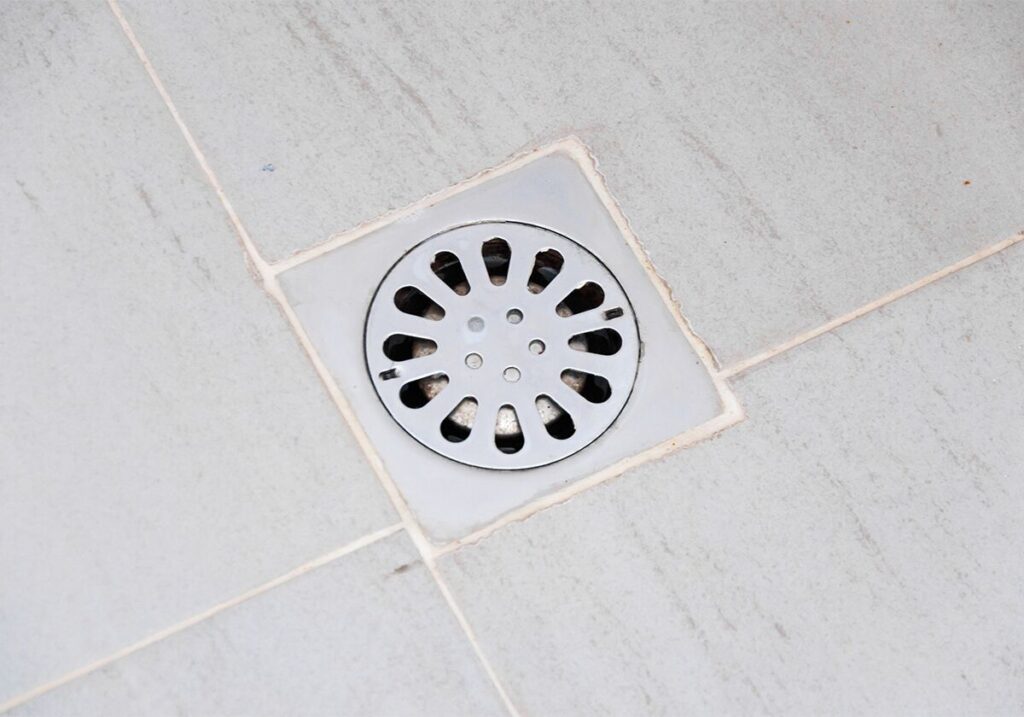 ralo de chão em piso de granito claro