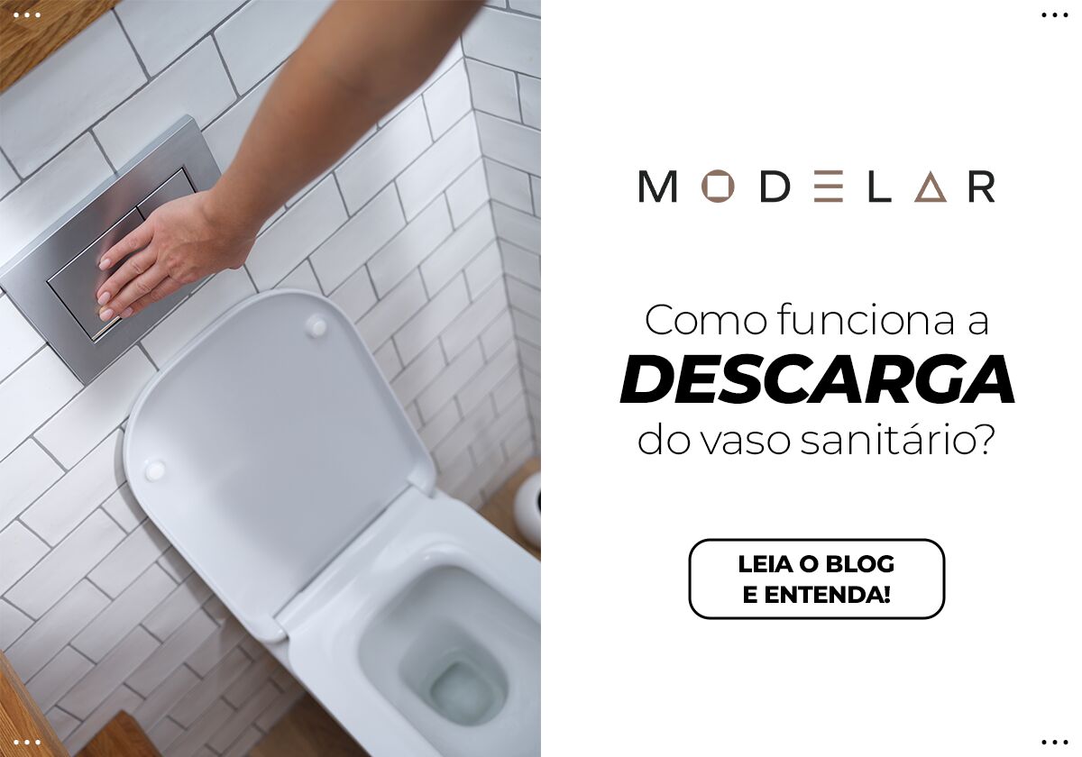 Mão acionando descarga em vaso sanitário moderno.